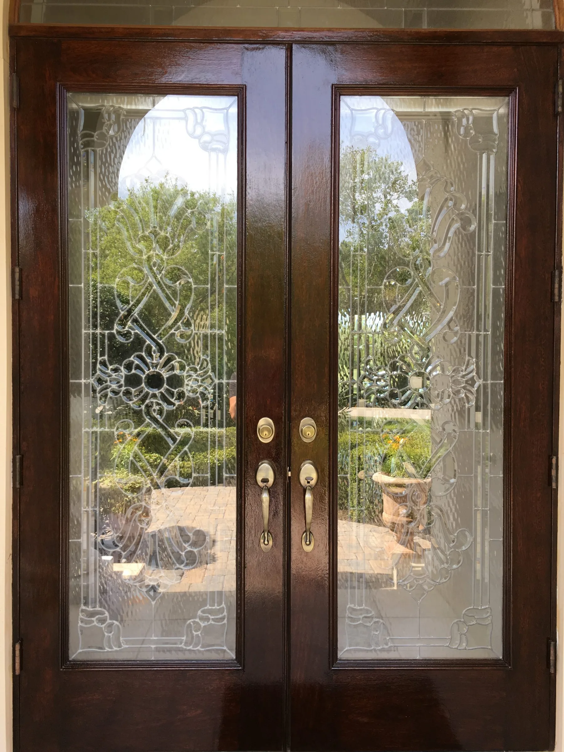 Antique brass handlesets on ornate mahogany double door