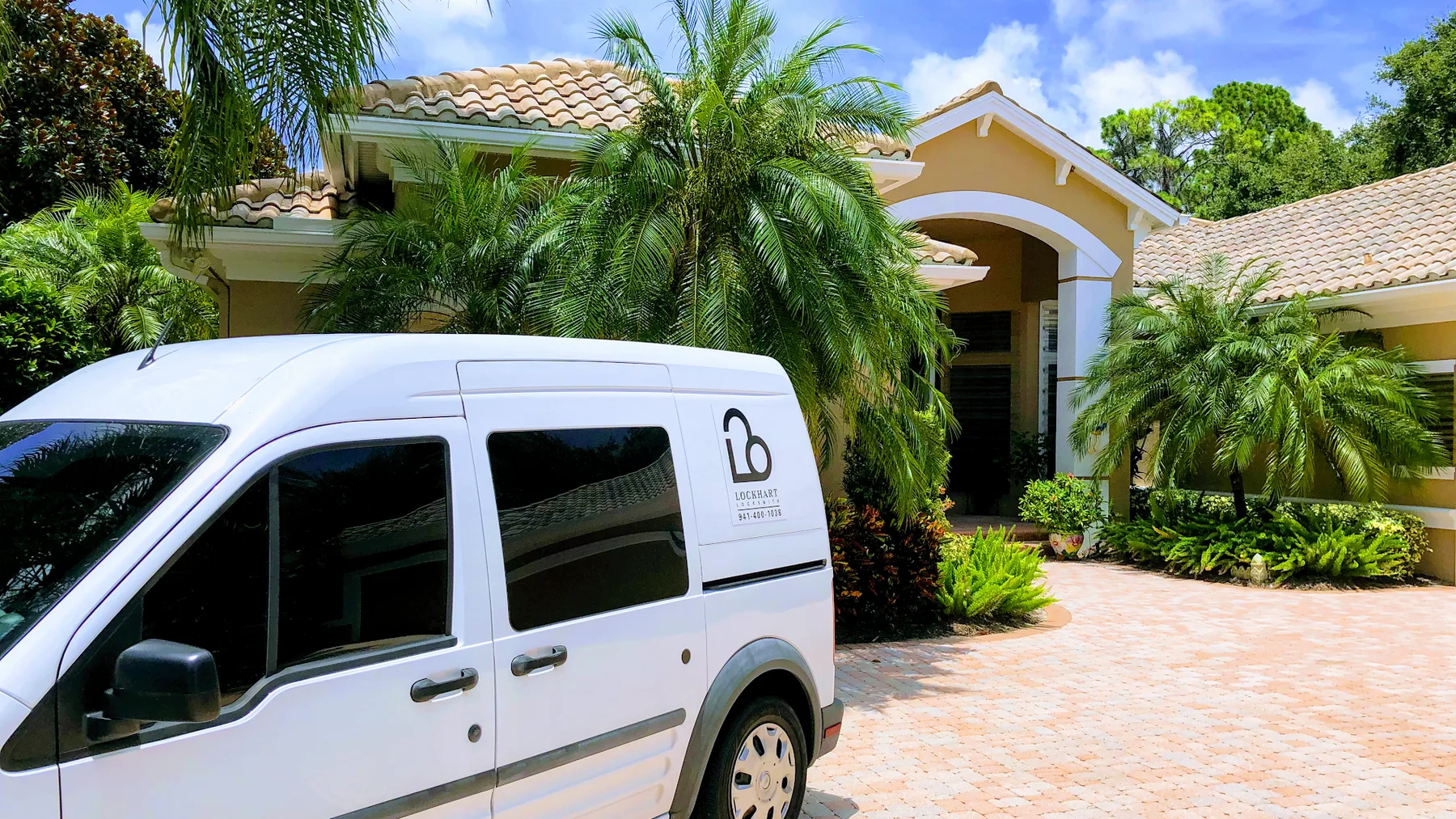 Lockhart Locksmith technician working at door with branded van and Florida sunset